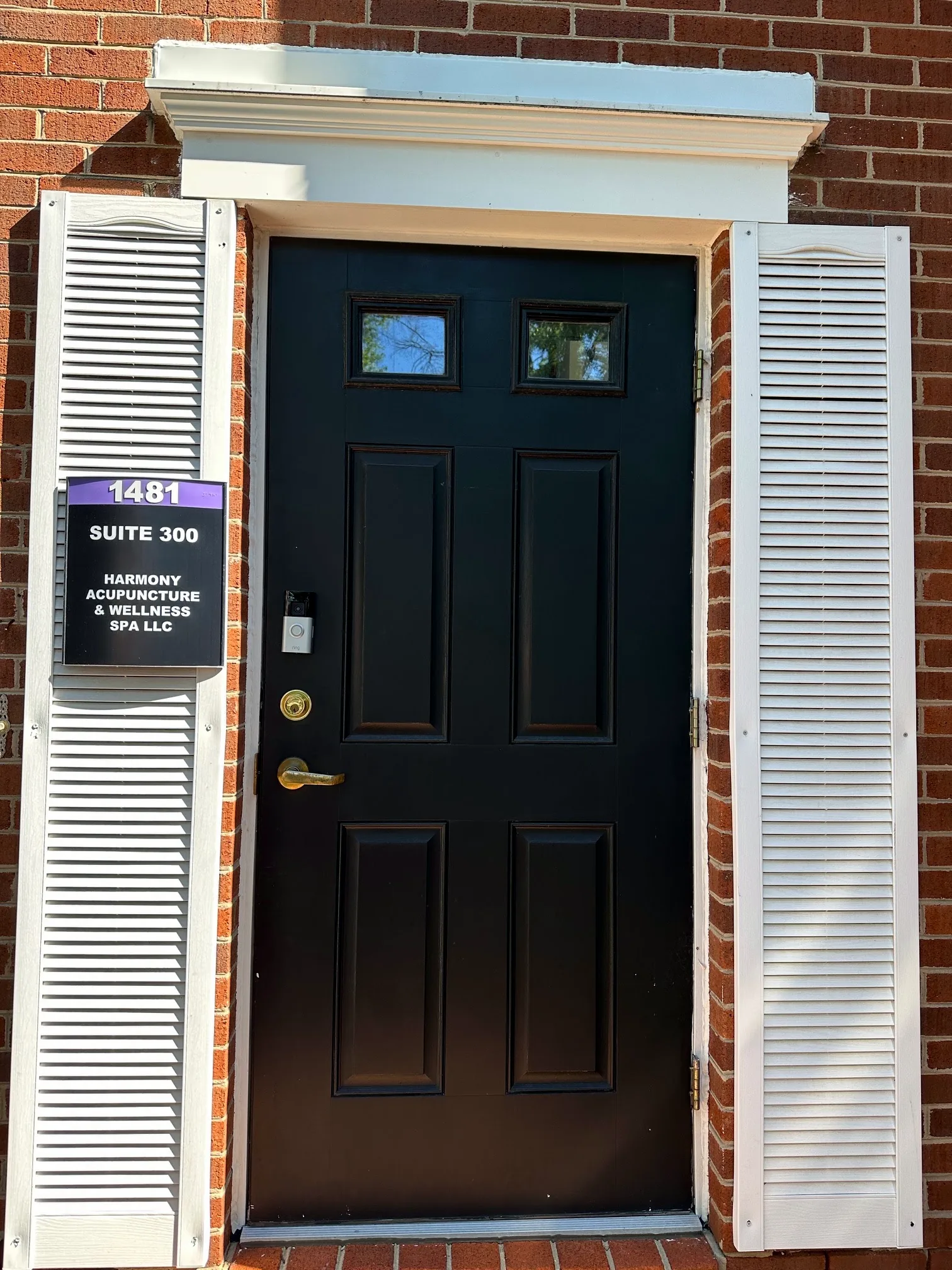 Entrance to Ste 300 at 1481 Chain Bridge Rd — red brick, white shutters, and a black front door